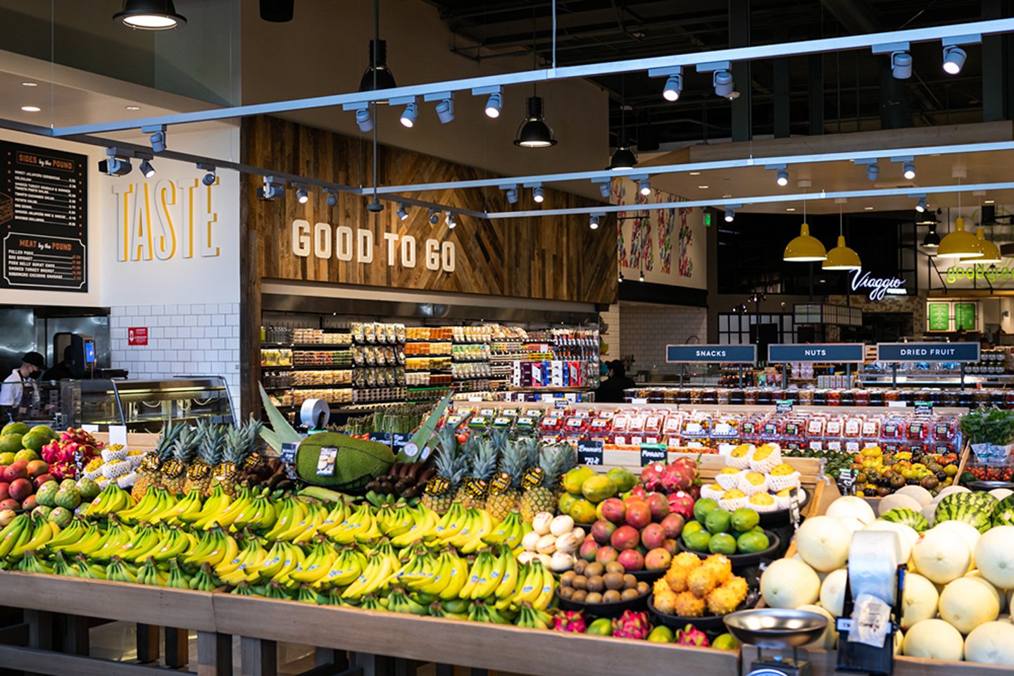 Bristol Farms produce hall with fresh fruit displays under exposed-beam lighting