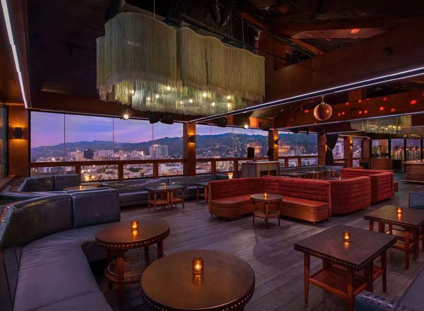 Rooftop lounge at the Dream Hollywood at dusk with views across Hollywood to the hills