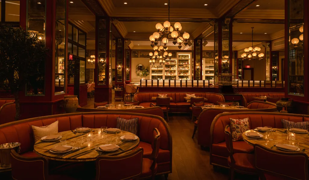 Mother Wolf dining room with red leather banquettes and globe chandeliers, one block west of the subject